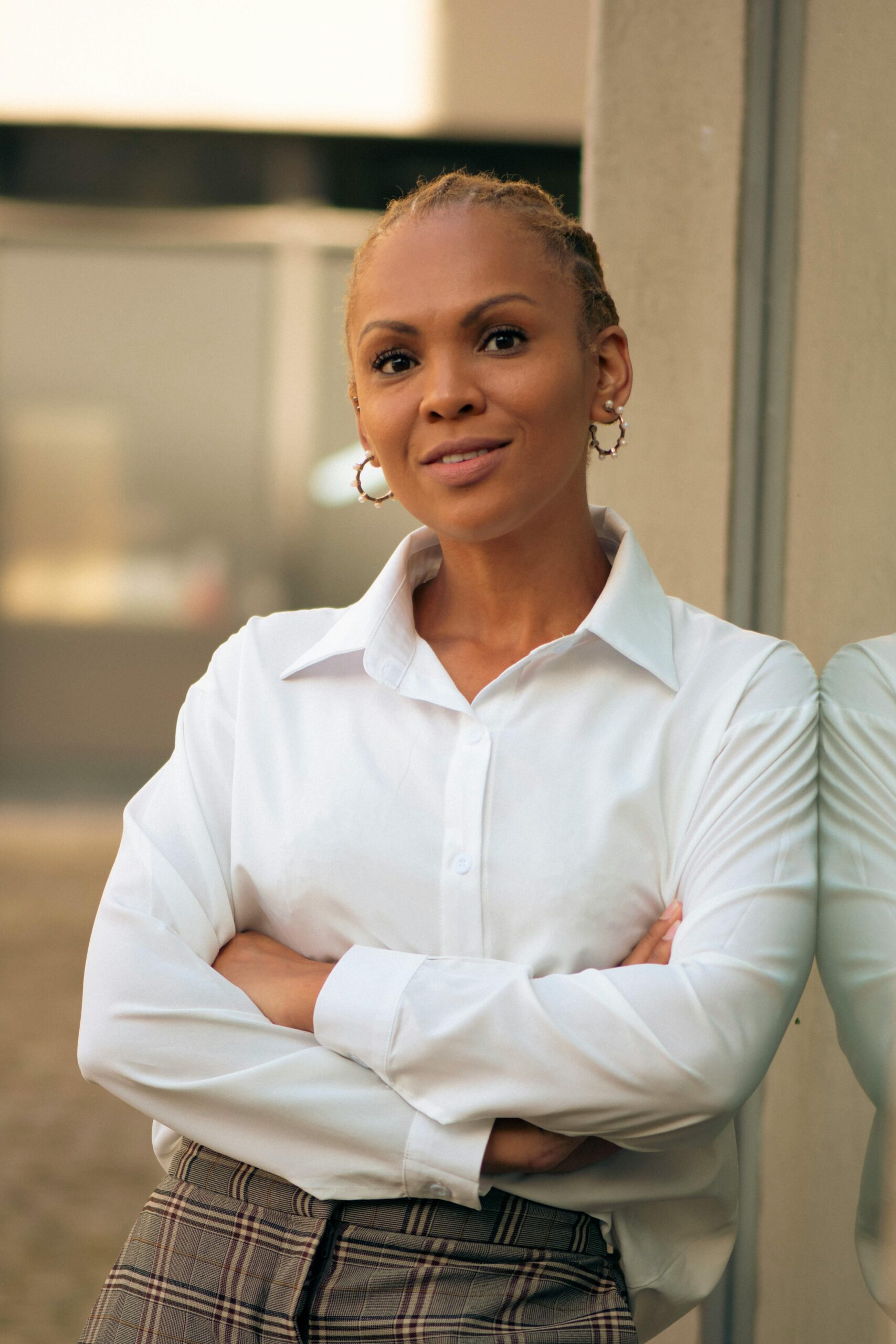 Portrait of a stylish woman in a white shirt, exuding elegance in Cape Town's outdoor setting.